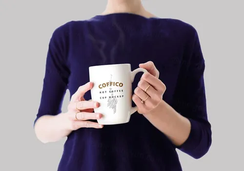 手拿杯子场景PSD贴图模板Woman Holding a Coffee Mug Mockup PSD
