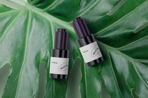 化妆品小瓶包装大片绿叶场景样机模板 Packagings On A Large Leaf Mockup Top View